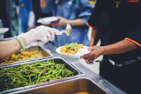 The hands of the poor are waiting to receive food from the rich, compassionate, free food donations to the homeless