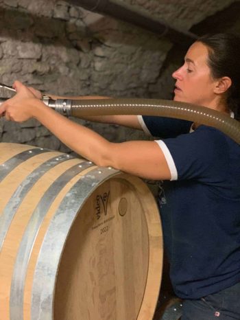 travail de vinification Anais remplit un fût de Chablis